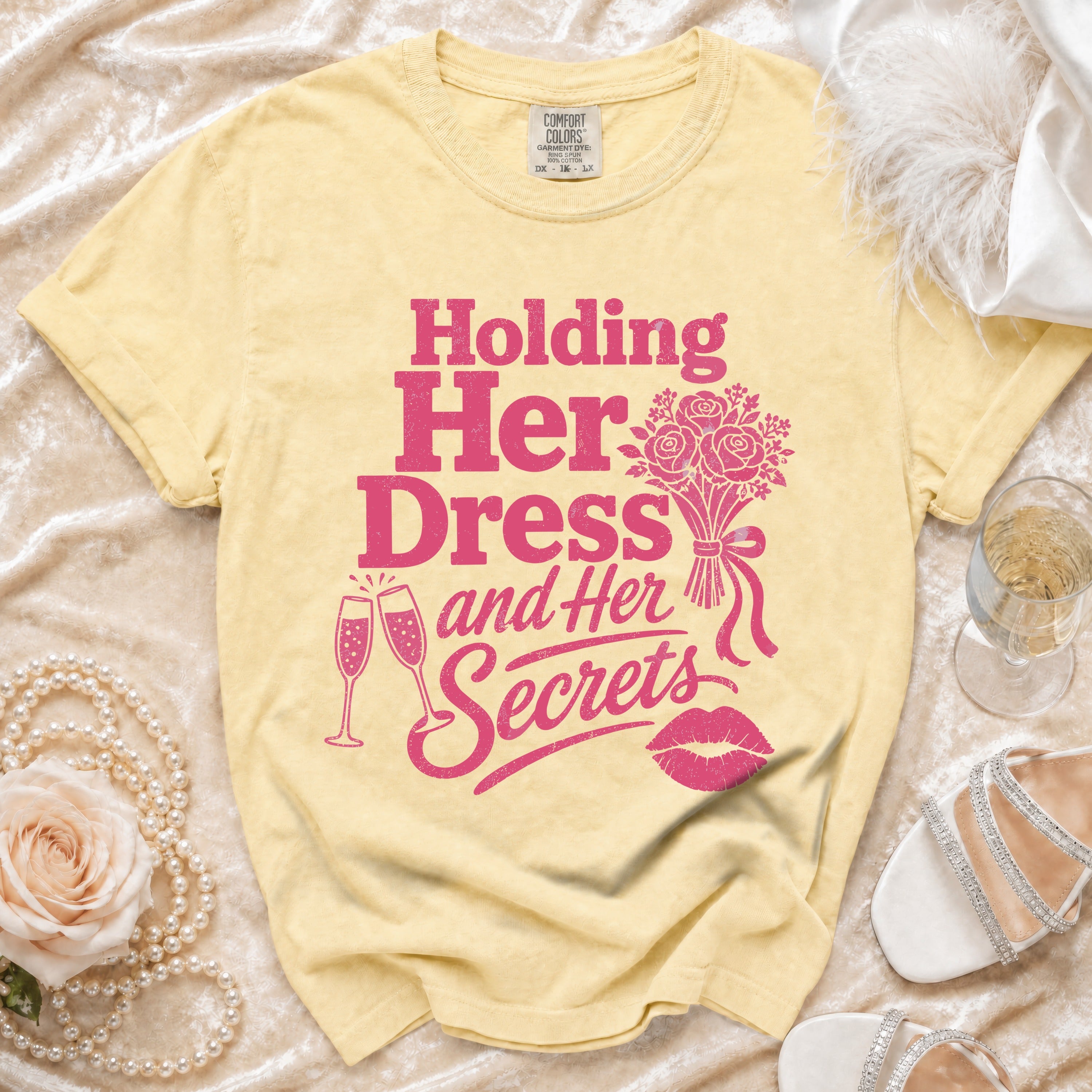 Yellow t-shirt with "Holding Her Dress and Her Secrets" graphic and accompanying icons.