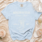 Light blue t-shirt with "Reckless in Texas Olivia's Bach" and "Austin, TX Disco Summer 2026."