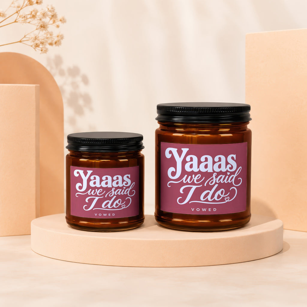 Two amber glass candles with black lids, featuring "Yaaas we said I do" text.