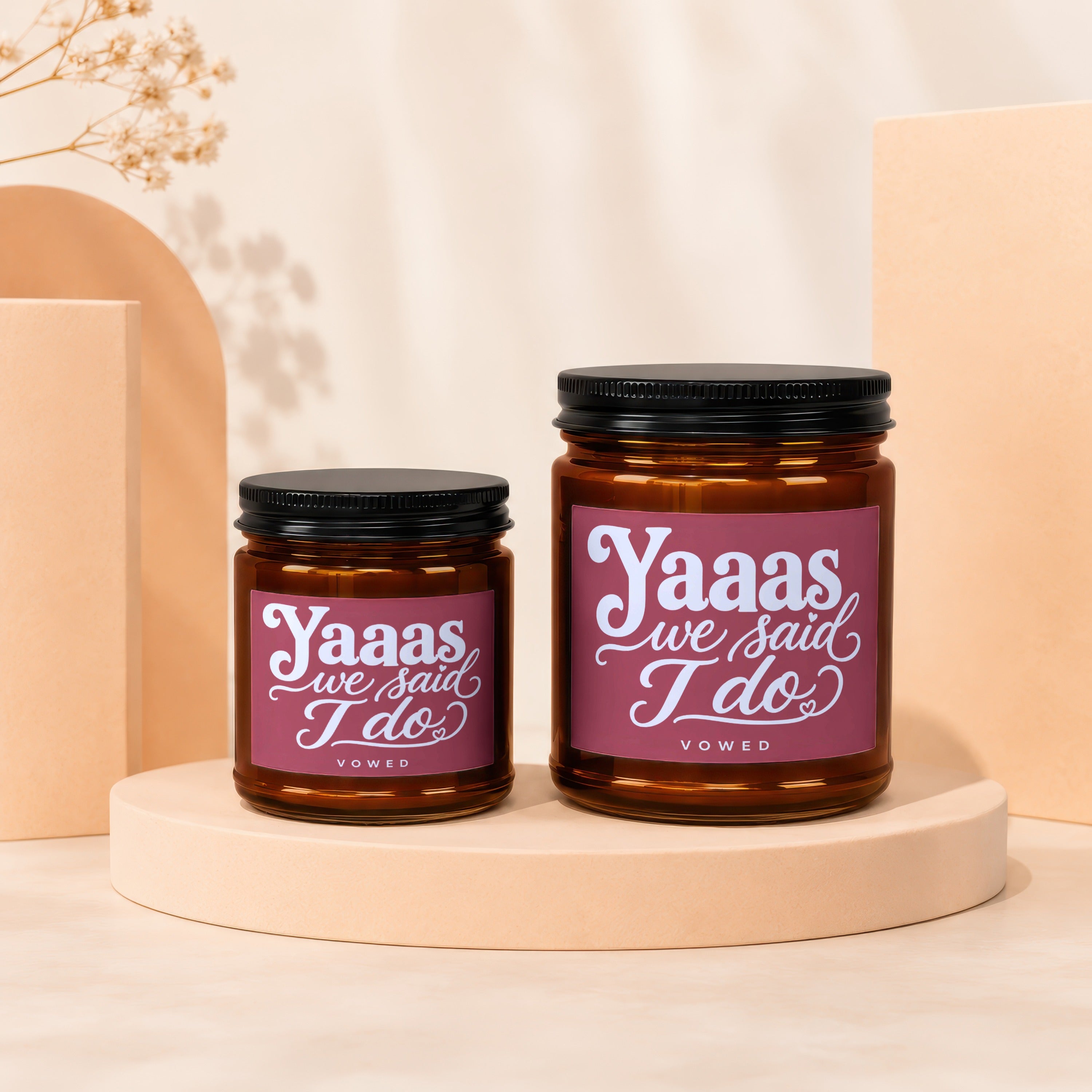 Two amber glass candles with black lids, featuring "Yaaas we said I do" text.