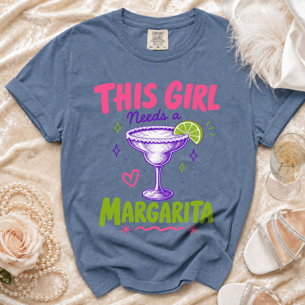 Blue t-shirt with pink and green text "This girl needs a margarita" and margarita graphic.