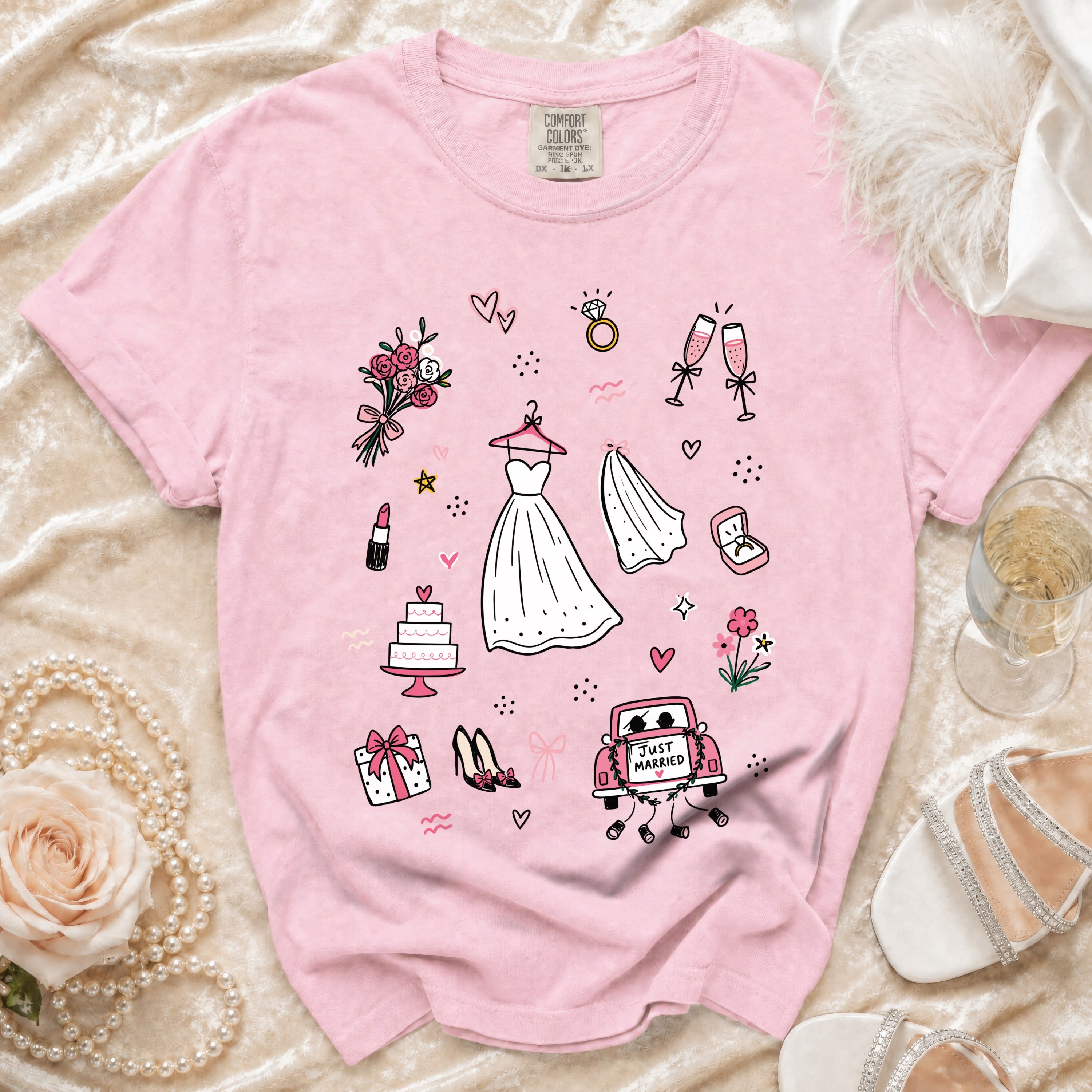 Pink t-shirt with wedding icons: dress, cake, rings, and "Just Married" car.