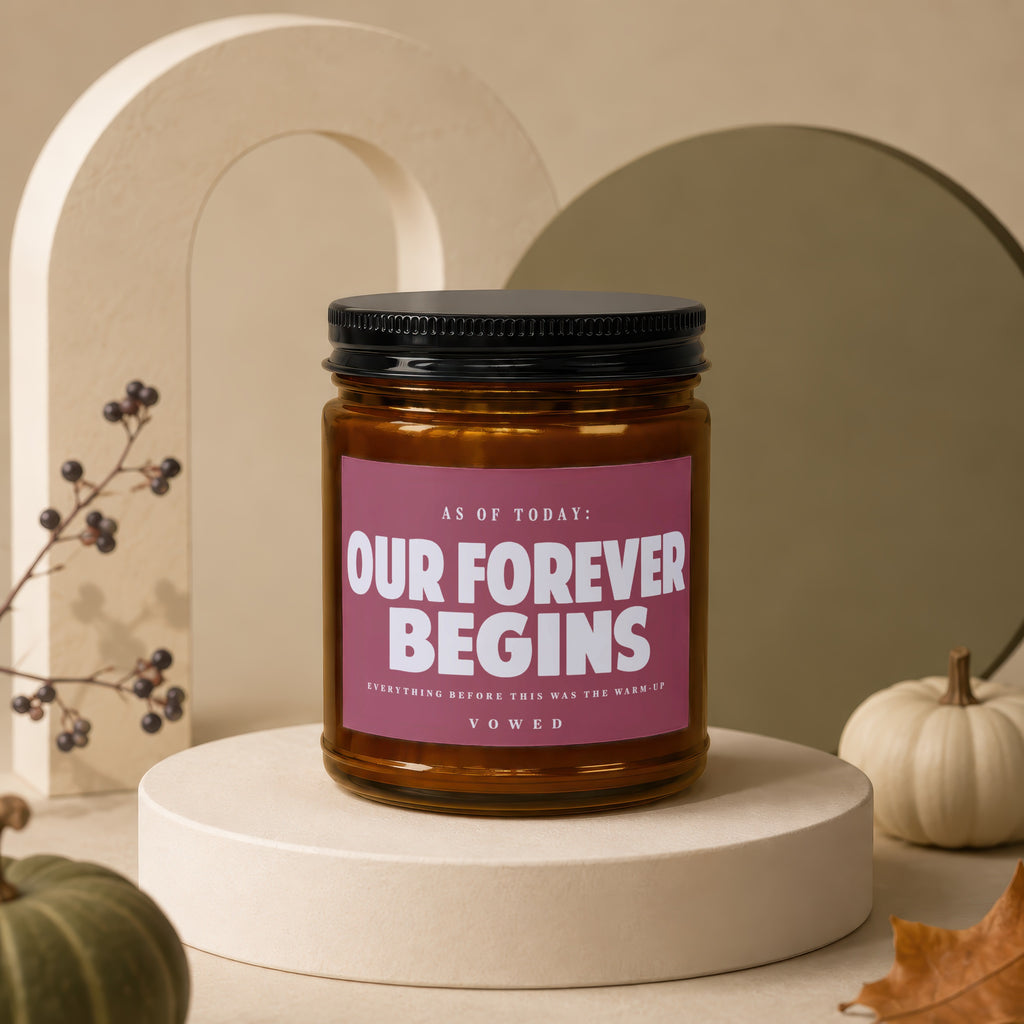 Amber jar candle with text "Our Forever Begins" on a maroon label.