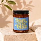 Amber jar candle with blue label reading "Here for the I Do's VOWED".