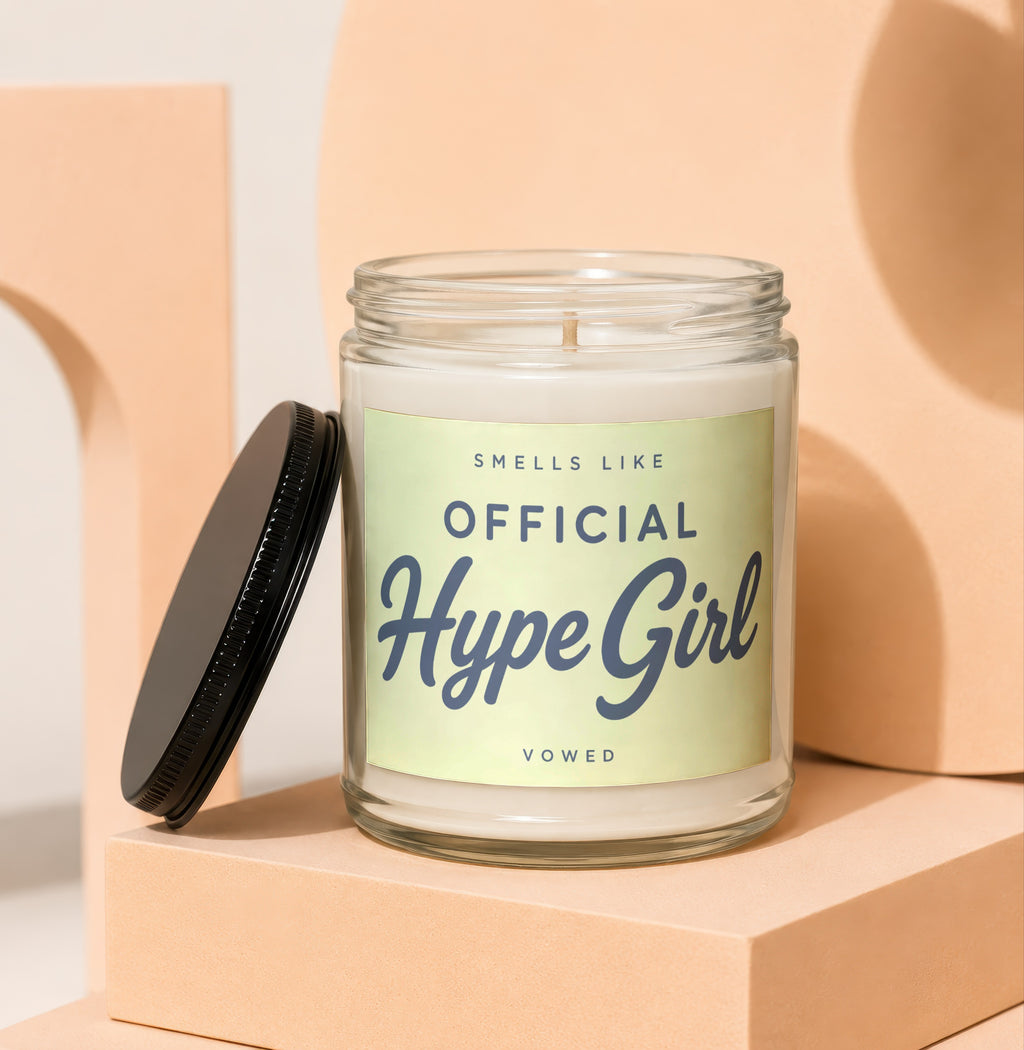 Glass candle with a light green label that reads "SMELLS LIKE OFFICIAL Hype Girl VOWED".