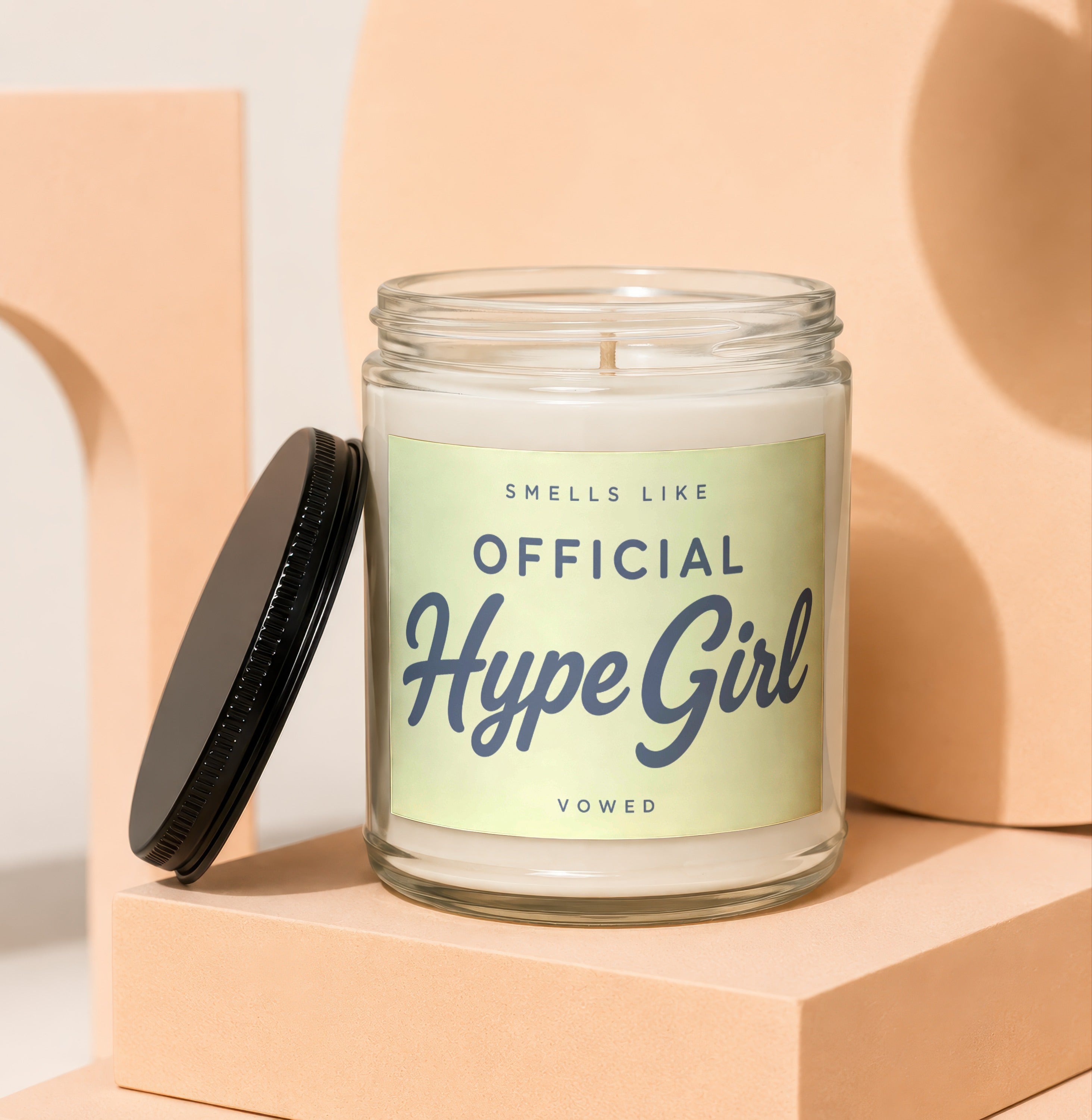 Glass candle with a light green label that reads "SMELLS LIKE OFFICIAL Hype Girl VOWED".