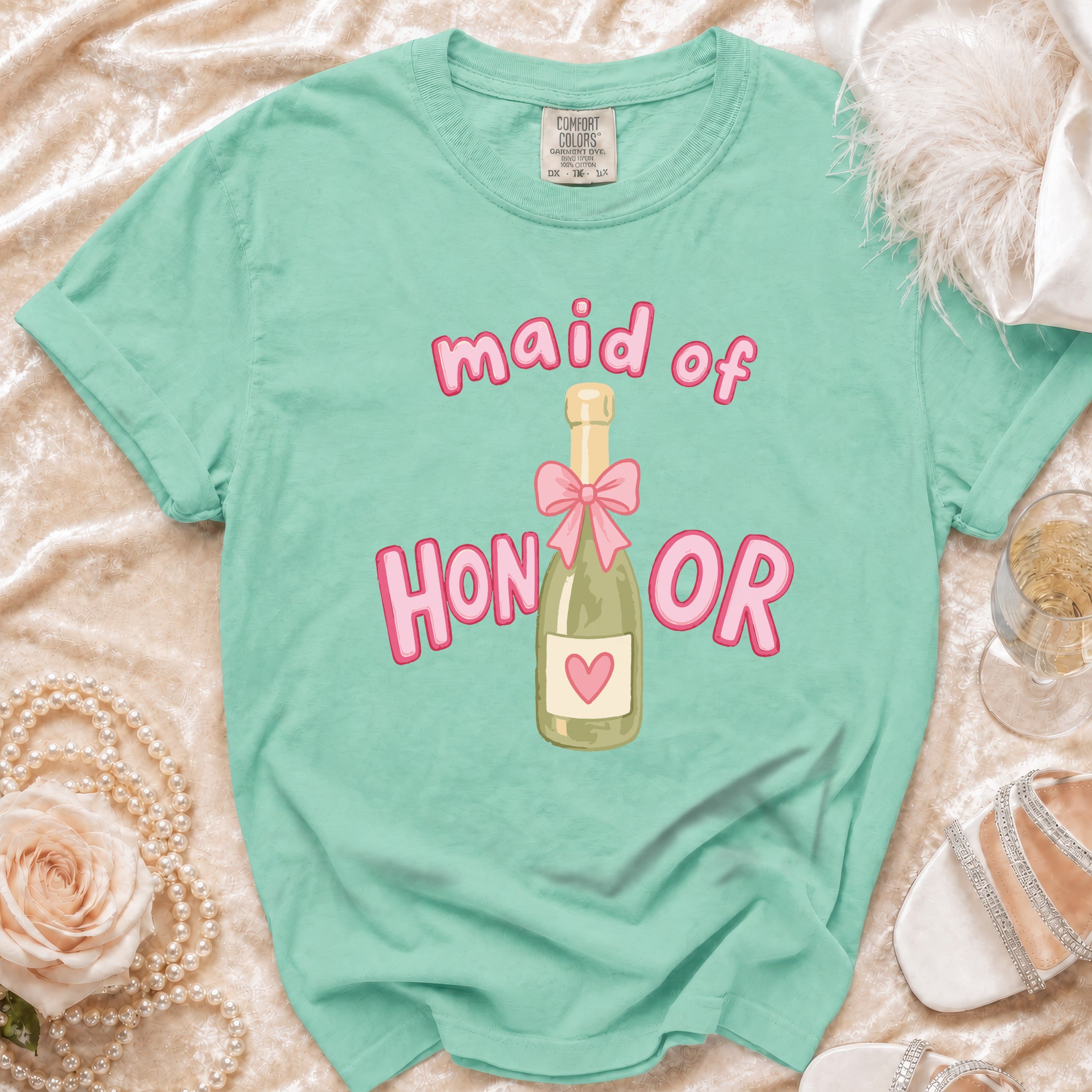 Mint green t-shirt with "Maid of Honor" text and champagne bottle graphic.