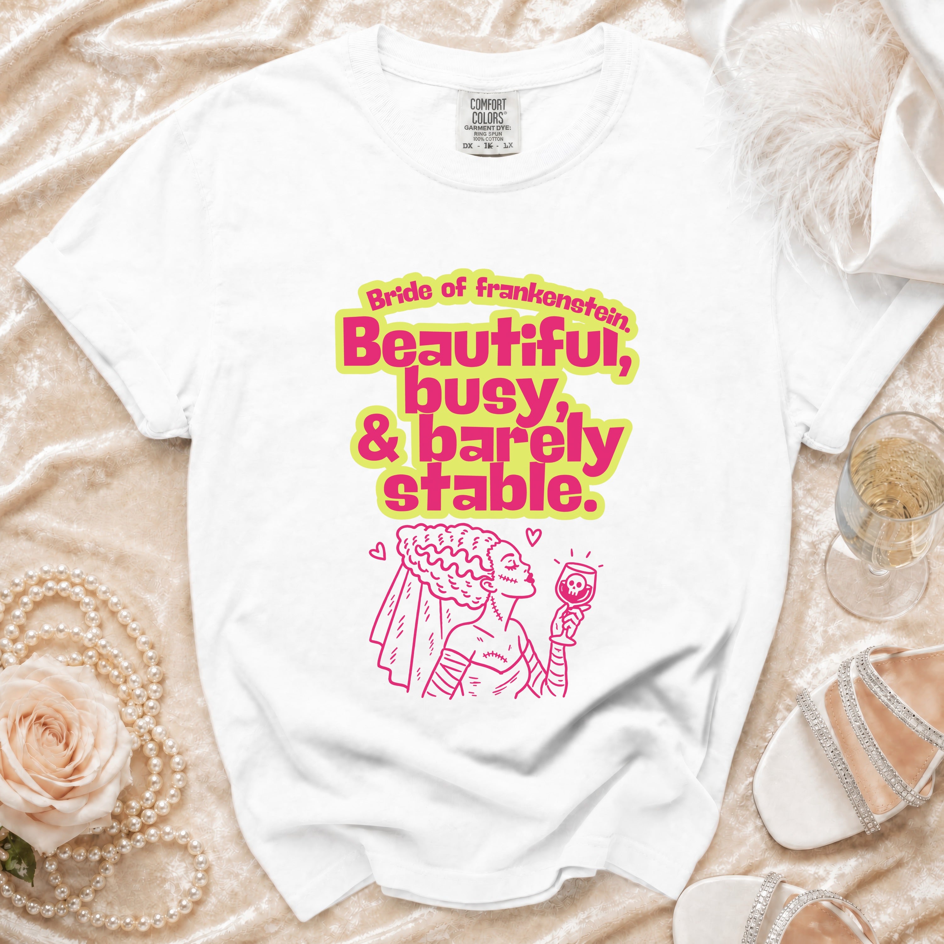 White t-shirt with "Bride of Frankenstein. Beautiful, busy, & barely stable." text and illustration.