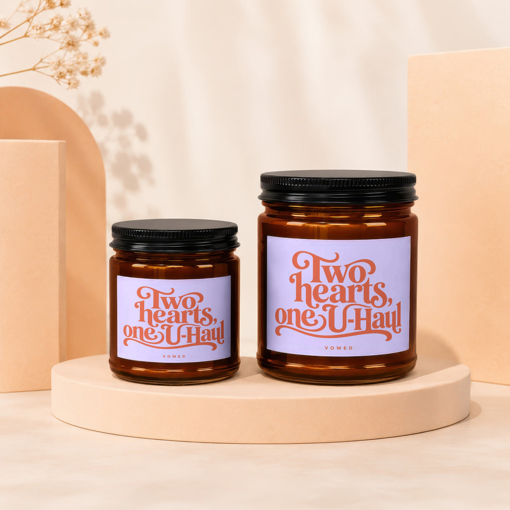Two glass candles with black lids and "Two hearts, one U-Haul" text.