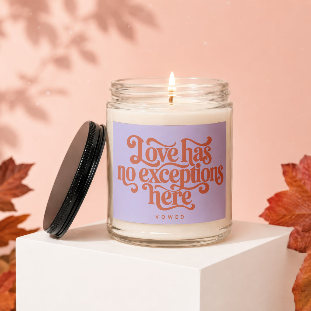 Lit candle in glass jar with "Love has no exceptions here" text.