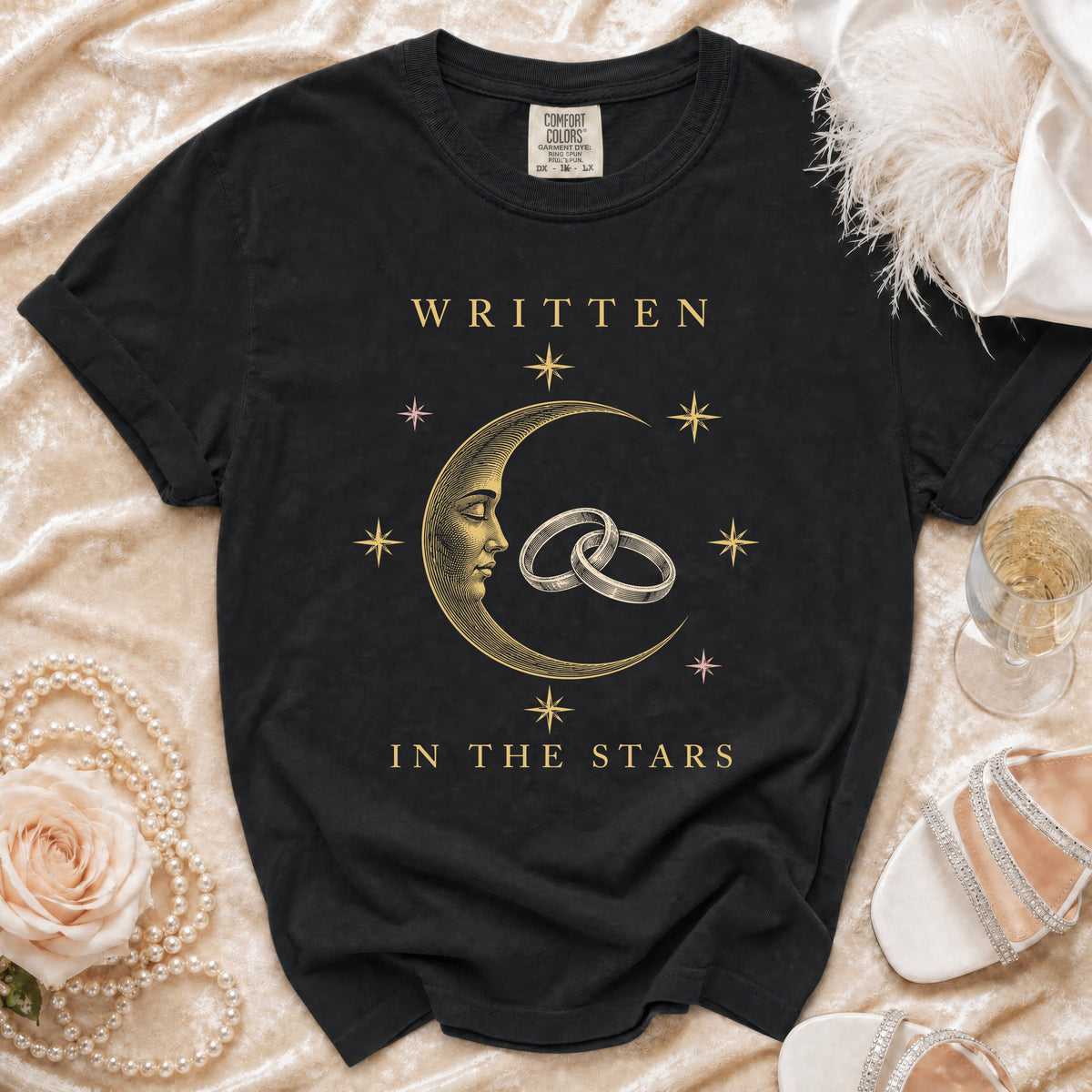 Black t-shirt with "Written in the Stars" text and celestial moon and rings graphic.