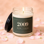 Candle with "Ruth + Caleb 2009 Still Going Strong" on label, surrounded by pink petals.