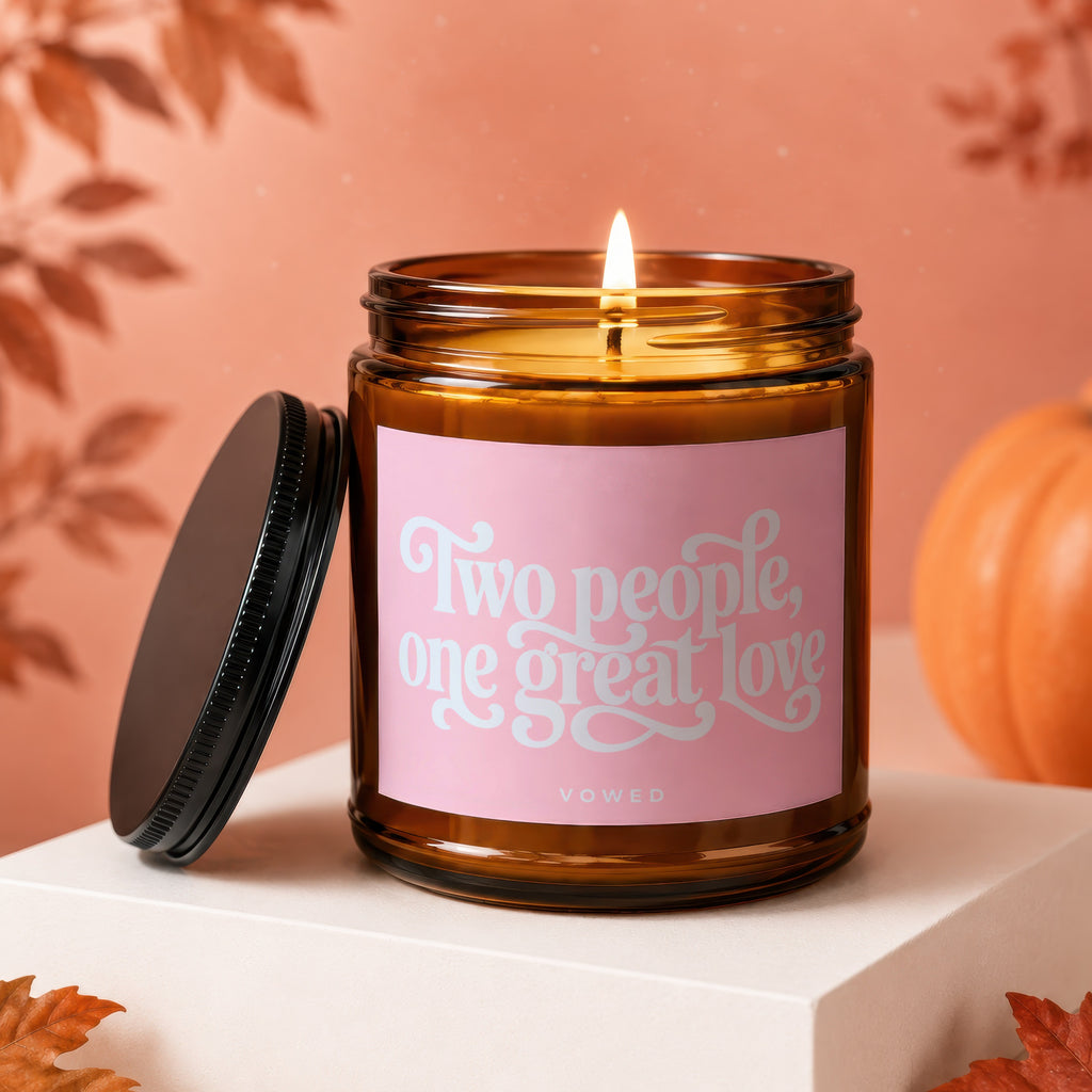 Amber glass candle burning, with label "Two people, one great love" and "VOWED".