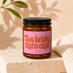 Candle with pink label reading "Two brides, zero chill" and "VOWED".