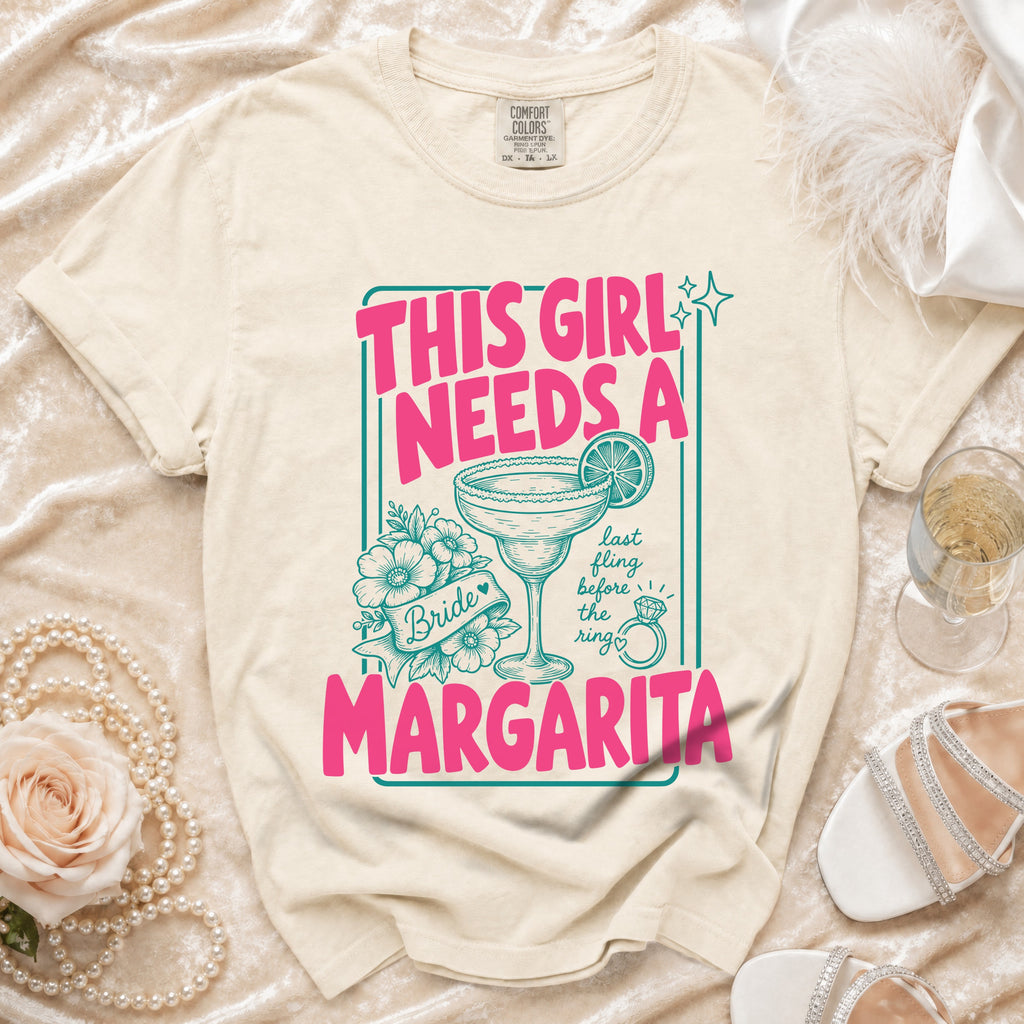 Cream t-shirt with pink text "THIS GIRL NEEDS A MARGARITA" and margarita graphic.