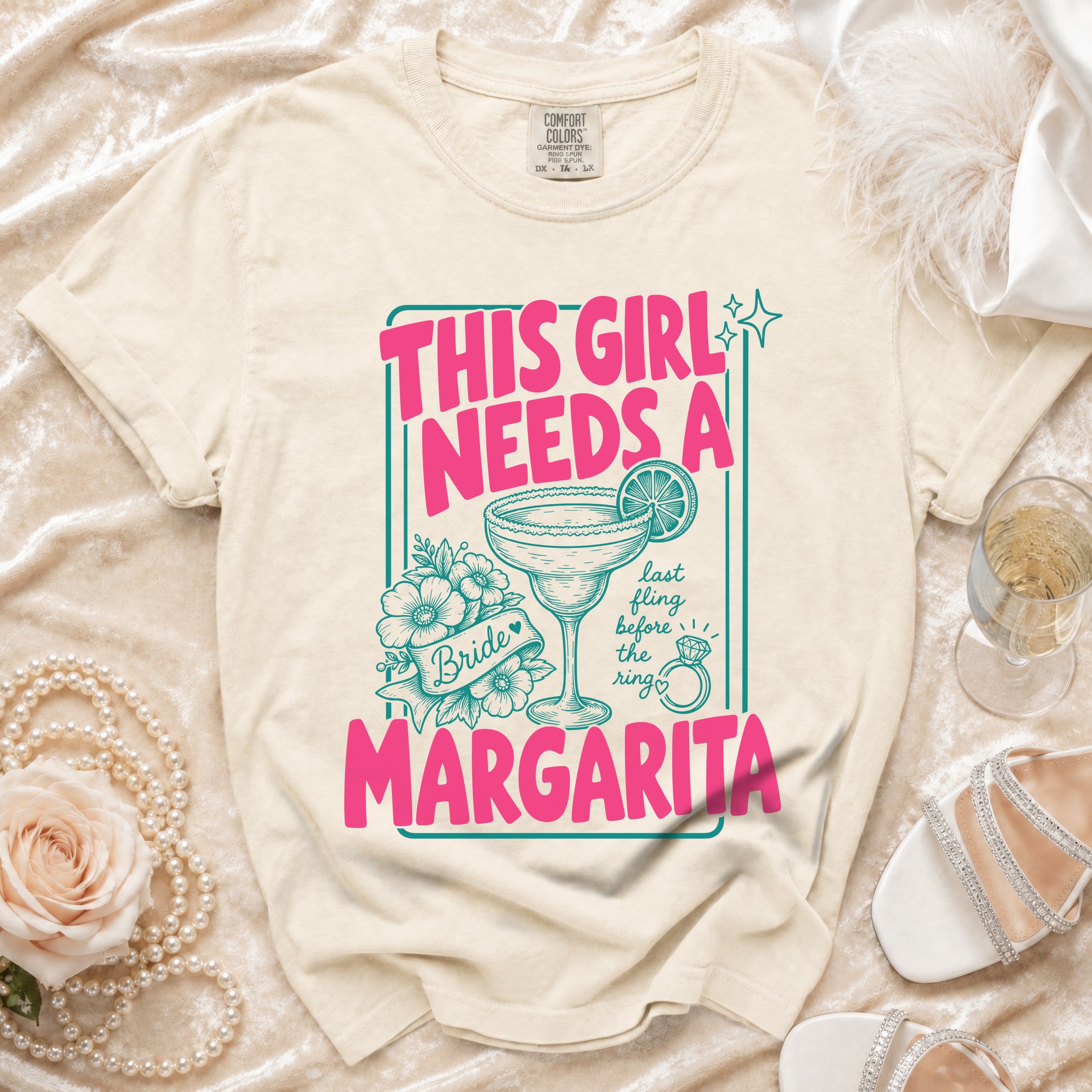 Cream t-shirt with pink text "THIS GIRL NEEDS A MARGARITA" and margarita graphic.