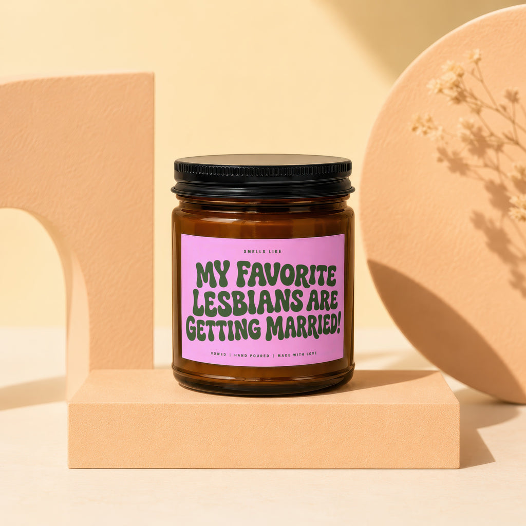 Amber jar candle with pink label stating "My favorite lesbians are getting married!".