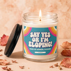 Glass jar candle with lid ajar, lit wick, and label saying "Say Yes Or I'm Eloping! Maid of Honor, Please!"