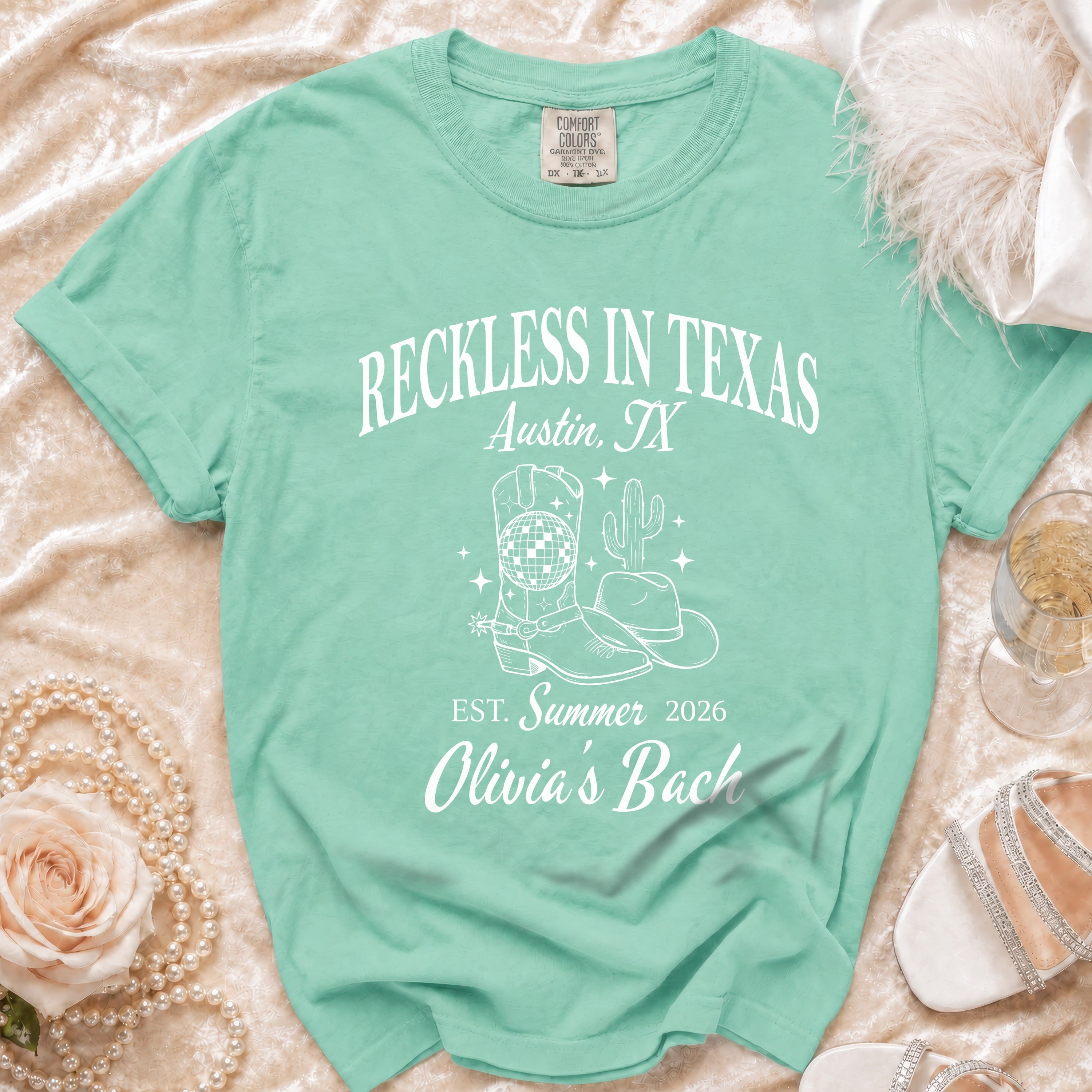 Mint green t-shirt with "Reckless in Texas Austin, TX" and western graphics.