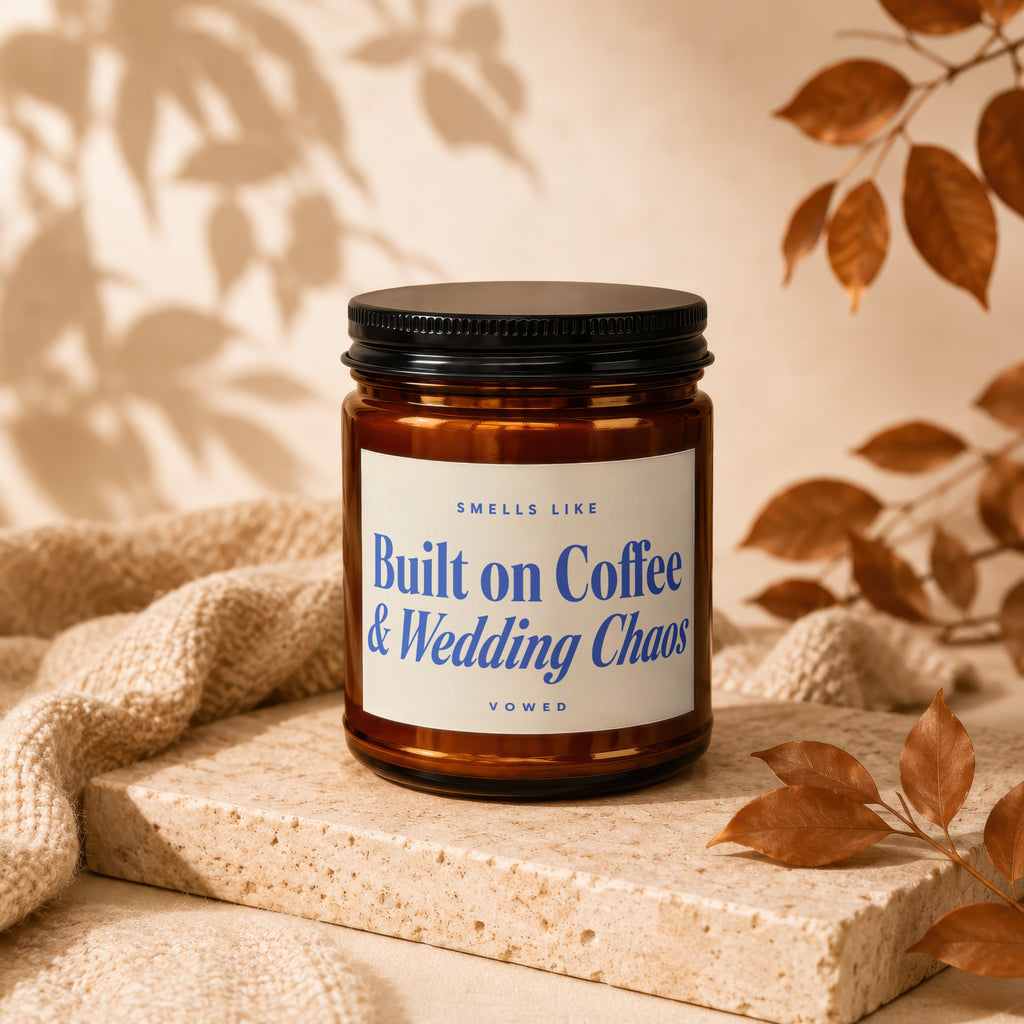 Amber jar candle with black lid, text reads "Smells Like Built on Coffee & Wedding Chaos Vowed".