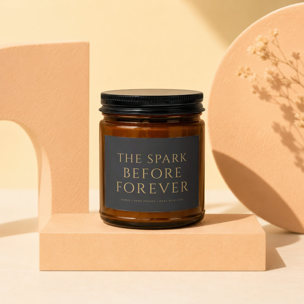 Amber jar candle with black lid and label "THE SPARK BEFORE FOREVER," "VOWED | HAND POURED | MADE WITH LOVE".