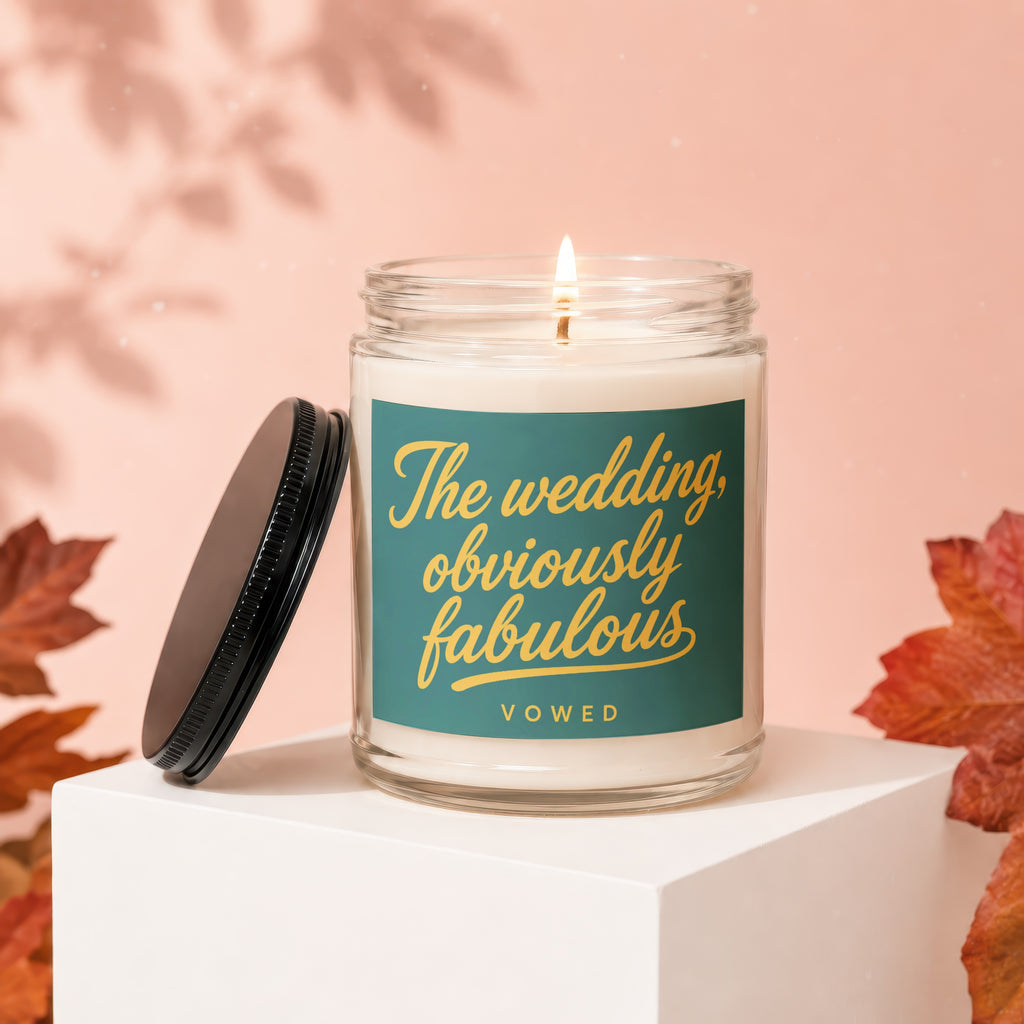 Lit candle in a jar with a teal label that reads "The wedding, obviously fabulous VOWED".