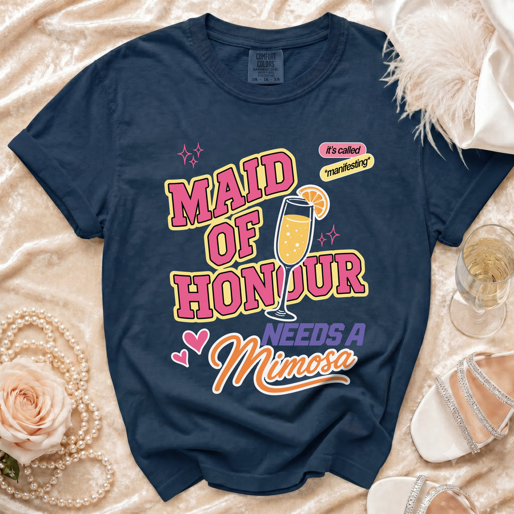 Navy t-shirt with text "Maid of Honour Needs A Mimosa" and a champagne glass graphic.