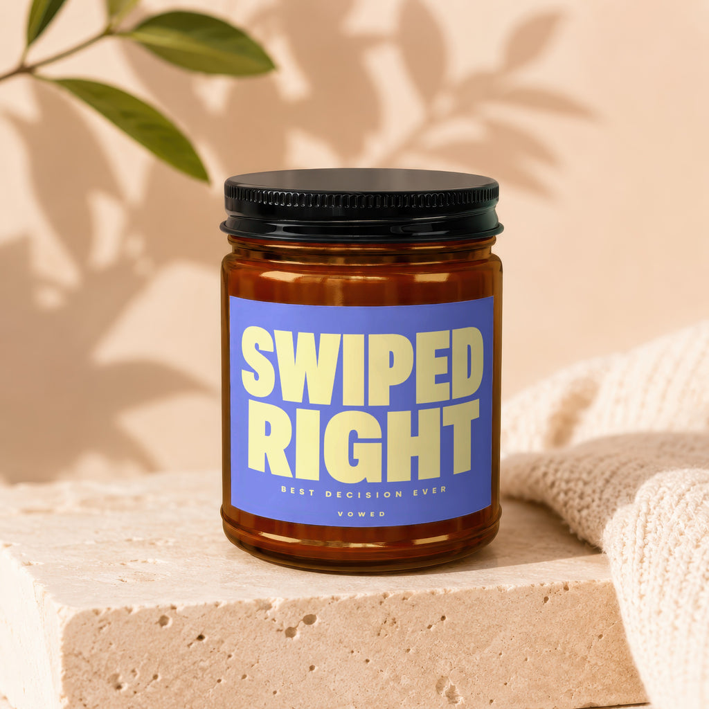 Candle labeled "SWIPED RIGHT BEST DECISION EVER VOWED" on a textured block with fabric.