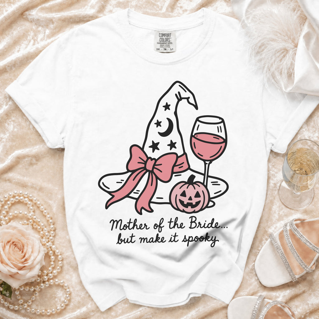 White t-shirt with witch hat, pumpkin, wine glass, and text "Mother of the Bride... but make it spooky."