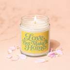 Lit candle in glass jar with "Love But Make It Home" text on yellow label.