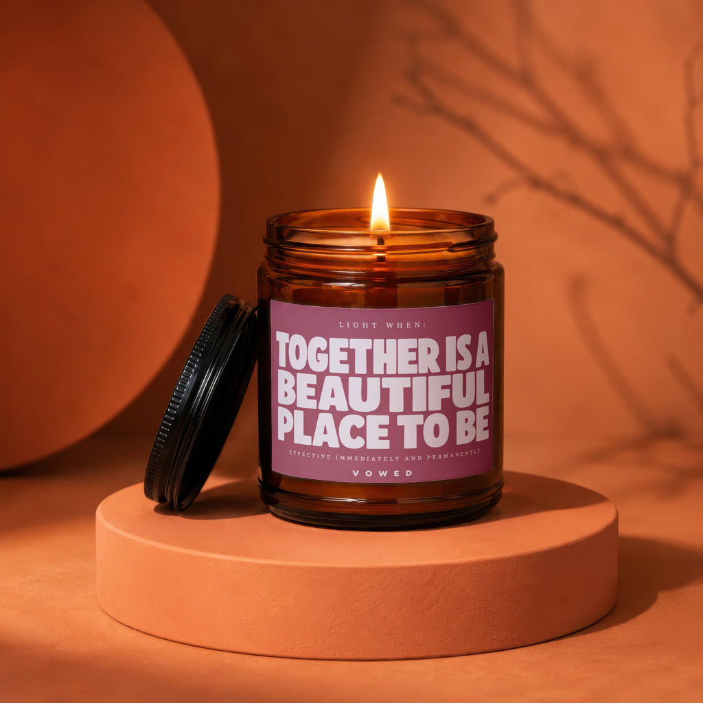Amber candle with lit flame and label "TOGETHER IS A BEAUTIFUL PLACE TO BE".