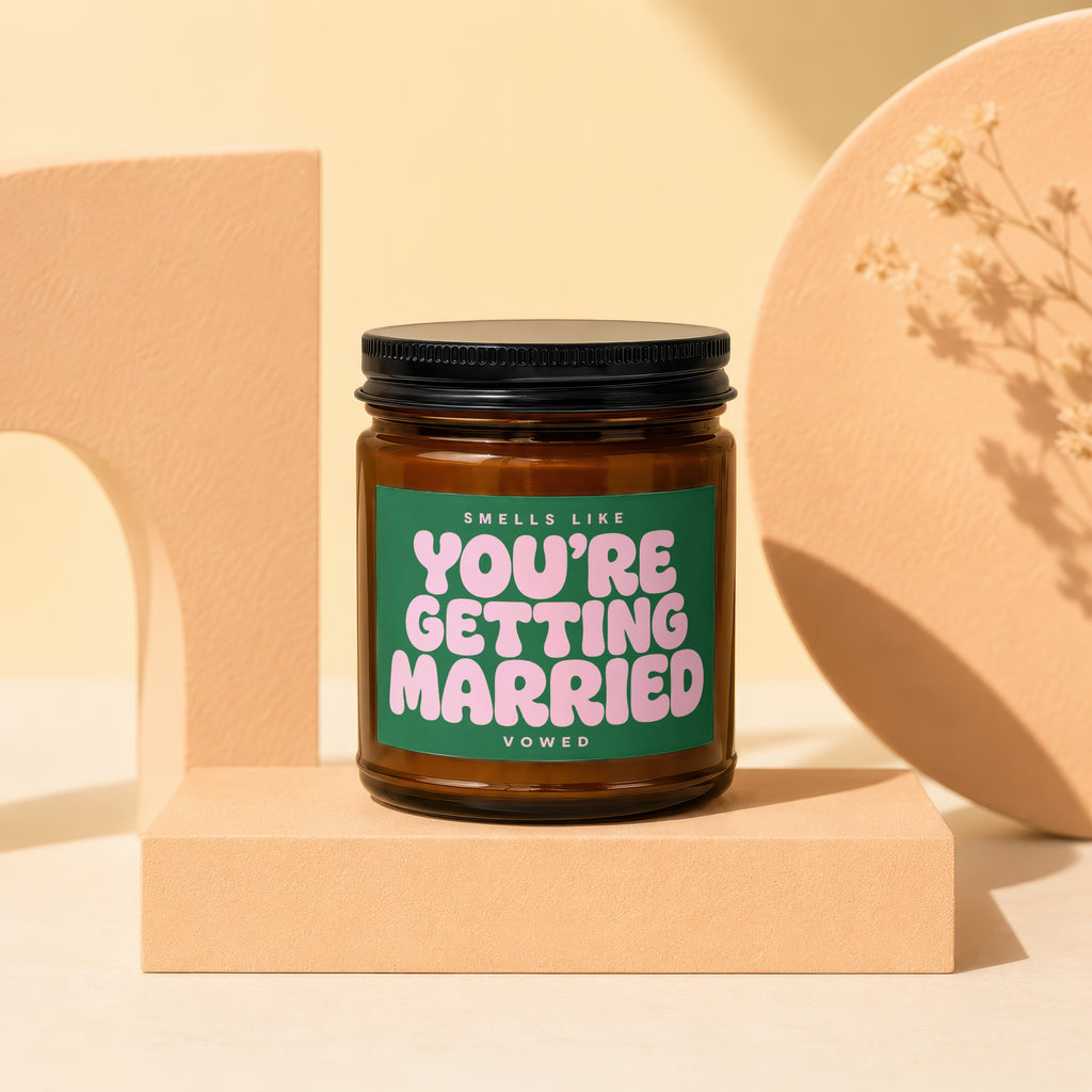 Amber jar candle with green label reading "Smells Like You're Getting Married"