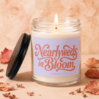 Candle with label "Nearlyweds in Bloom Vowed," lit with a flame.