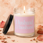 Lit glass candle with pink label reading "Husband & husband, vowed".