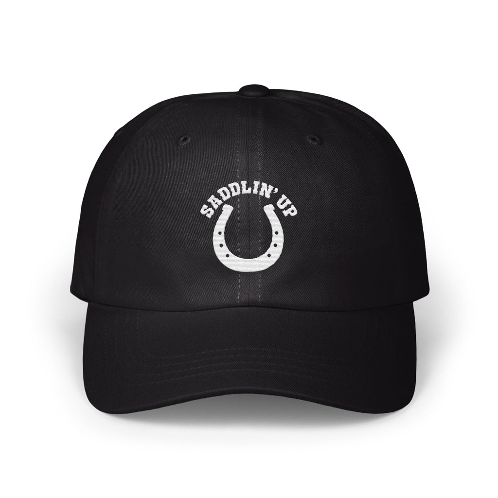 Black dad hat featuring a white embroidered horseshoe and the text SADDLIN' UP on the front panel.
