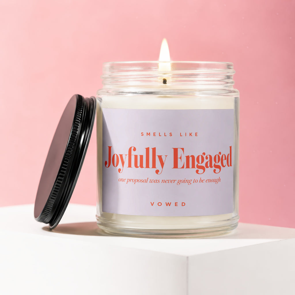 Lit jar candle with a black lid off to the side, labeled "Joyfully Engaged".