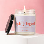 Lit jar candle with a black lid off to the side, labeled "Joyfully Engaged".