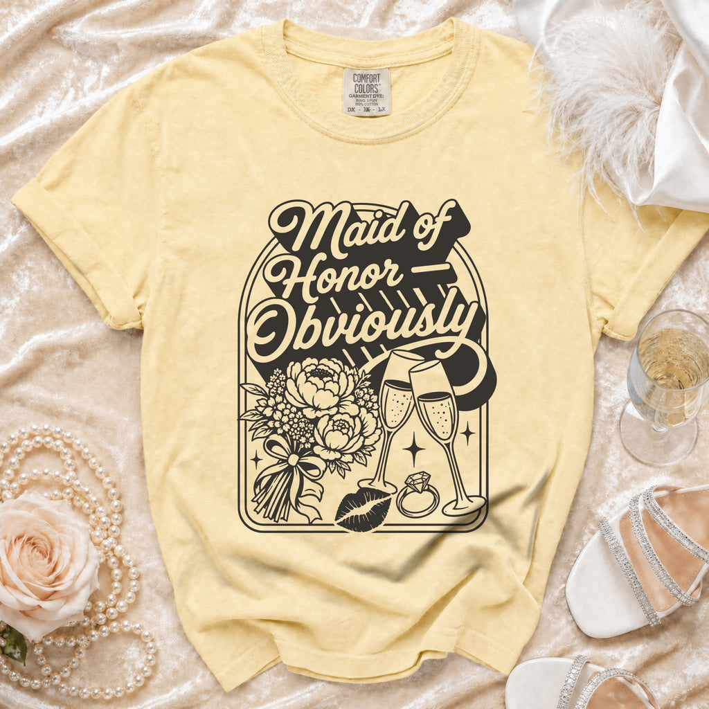 Yellow t-shirt with "Maid of Honor Obviously" graphic featuring flowers, champagne, kiss, and ring.