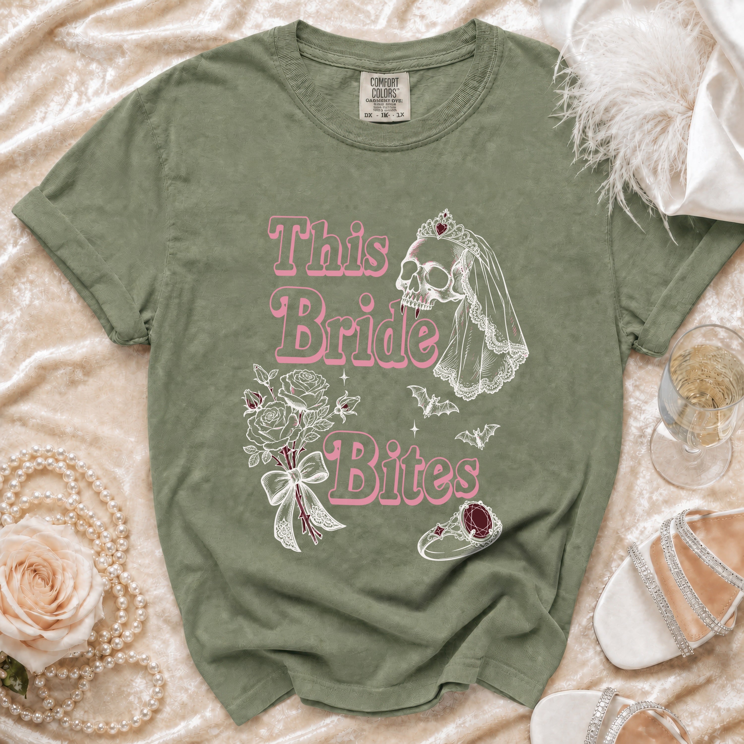 Green t-shirt with "This Bride Bites" text, skull, bats, roses, and ring graphic.