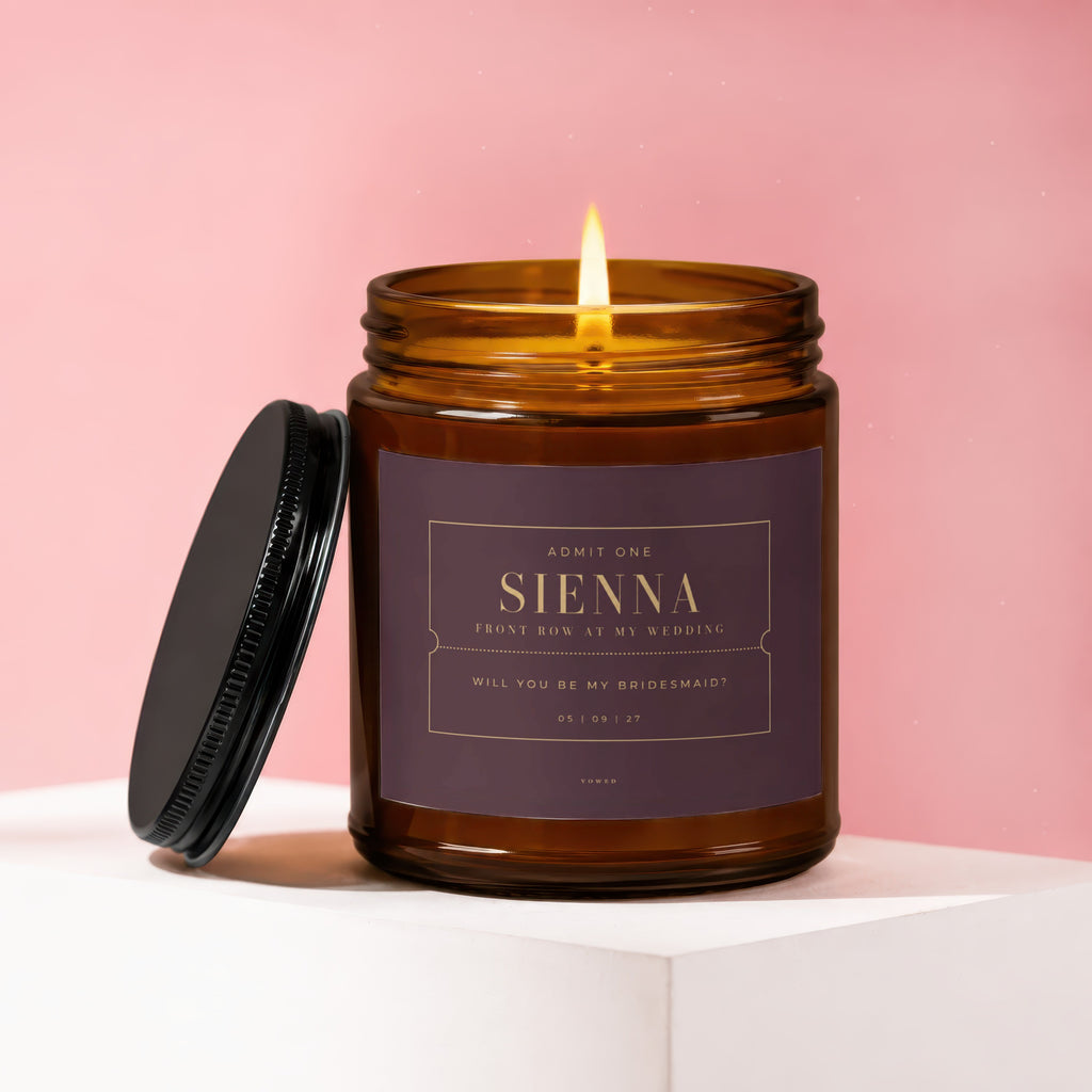 Amber jar candle with lit wick, reads "Sienna, Will You Be My Bridesmaid?".