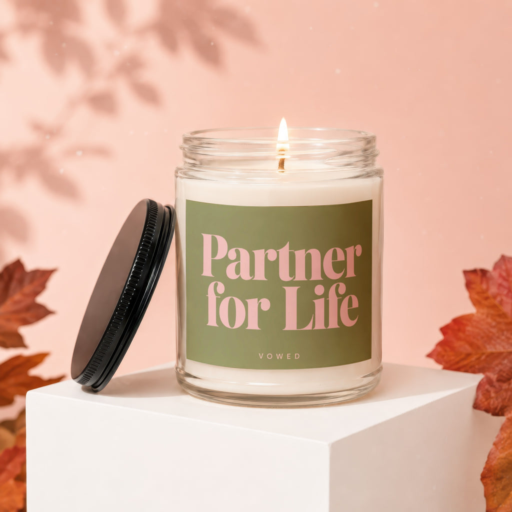 Candle with "Partner for Life VOWED" text on green label.