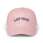 Pink baseball cap with navy blue "LAST TOAST" embroidery.
