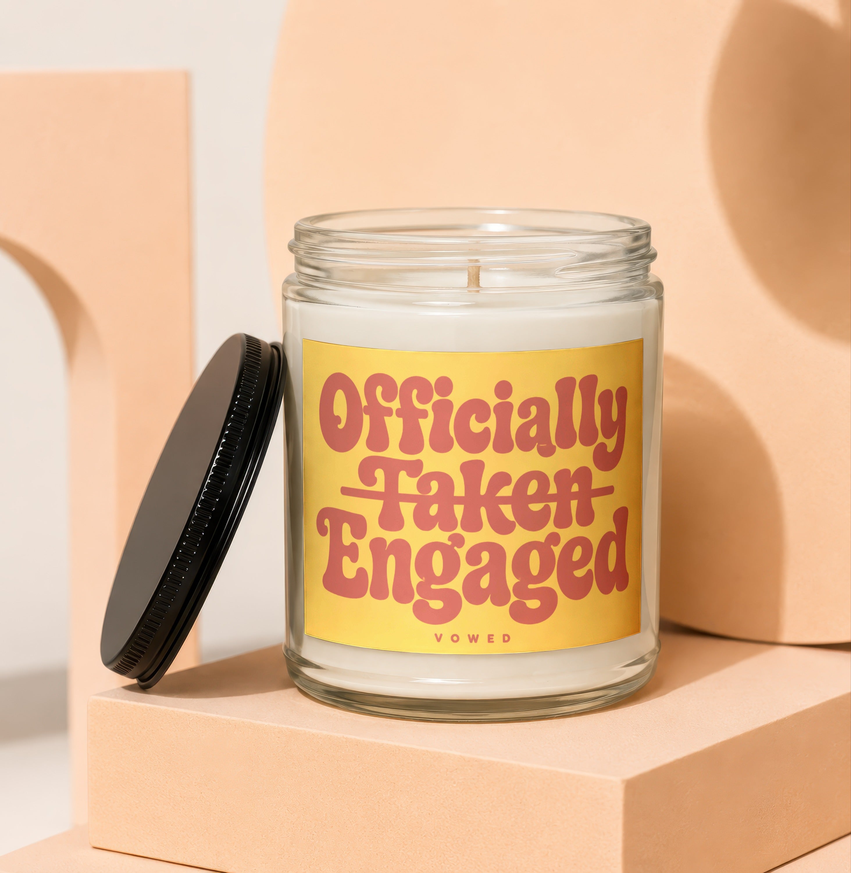 Glass candle with yellow label reading "Officially Taken Engaged VOWED".
