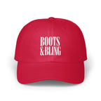 A red baseball cap with white embroidered text reading BOOTS & BLING centered on the front panels.