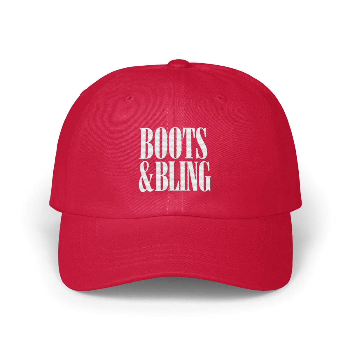 A red baseball cap with white embroidered text reading BOOTS & BLING centered on the front panels.