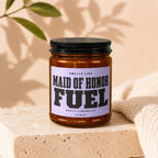 Candle labeled "Smells Like Maid of Honor Fuel. Apply Liberally. Vowed."