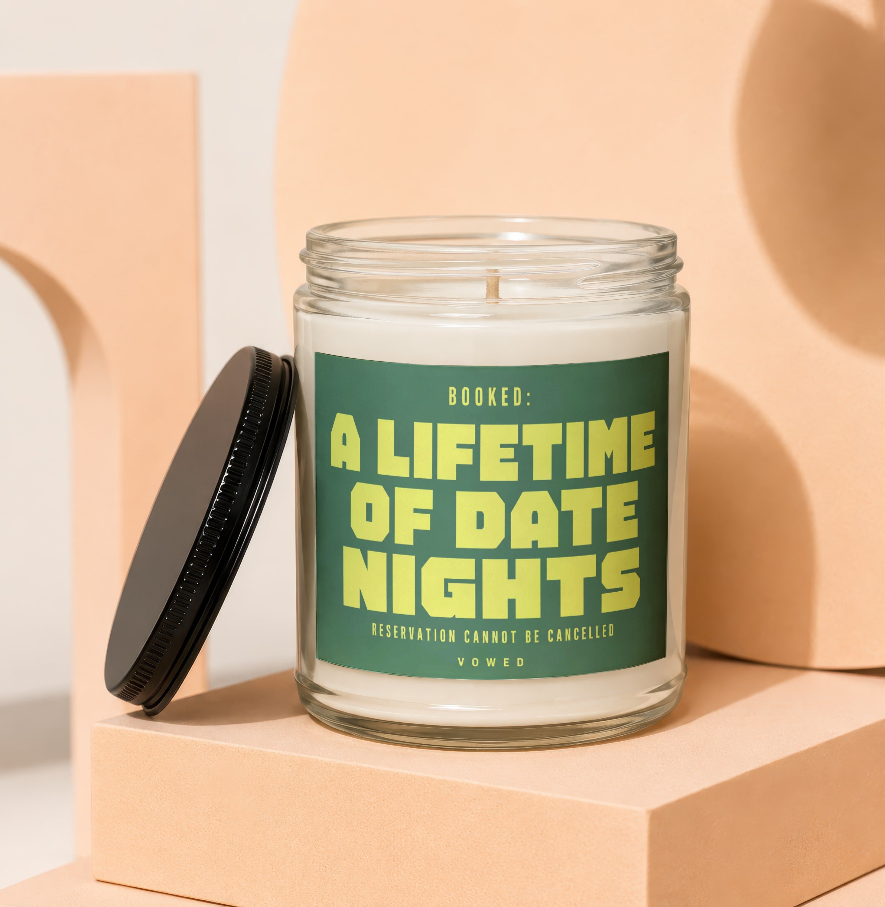 Glass candle with green label reading "Booked: A Lifetime of Date Nights"