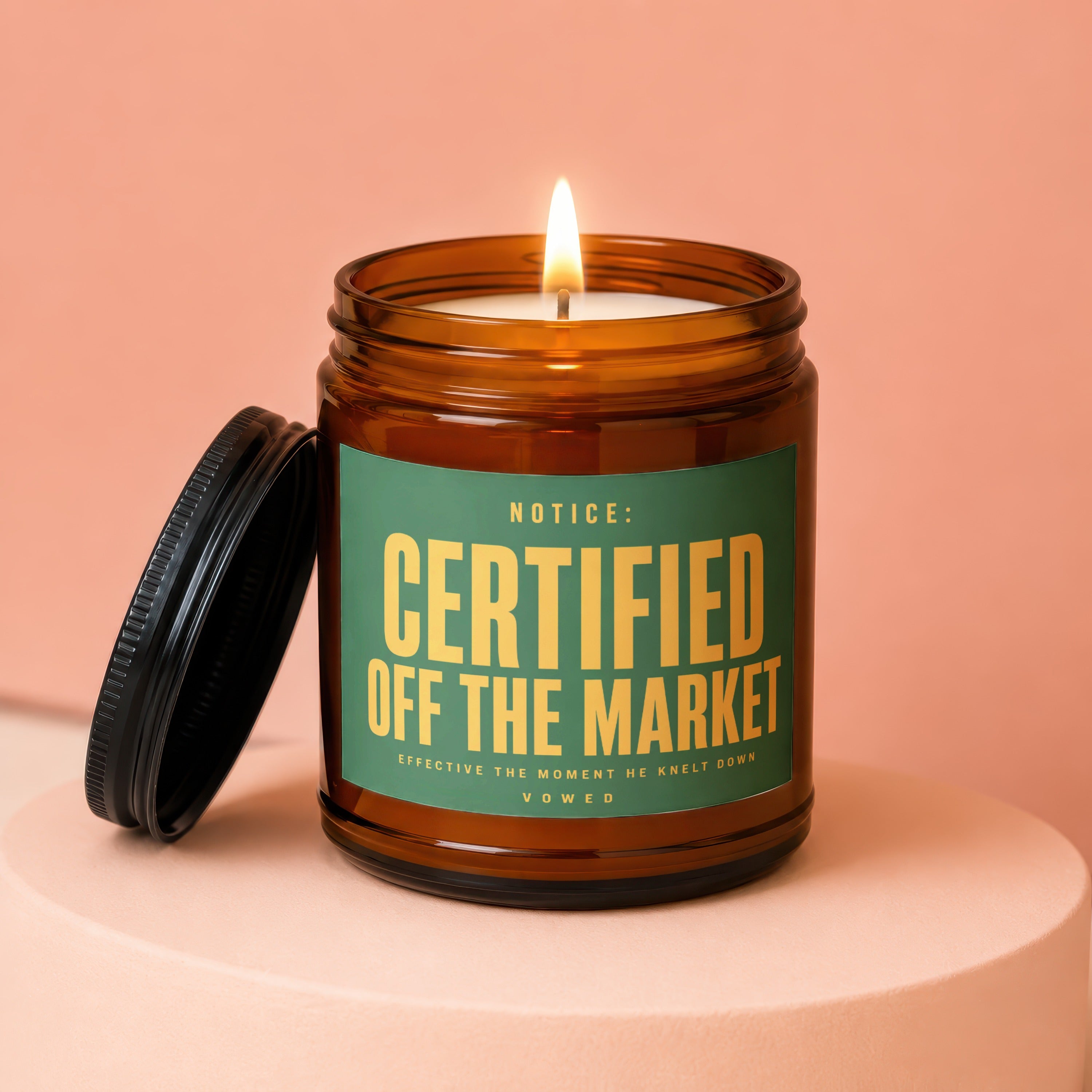 Amber glass candle with lit wick and black lid, labeled "Certified Off The Market"
