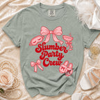 Sage green t-shirt with pink "Slumber Party Crew" text and graphics.