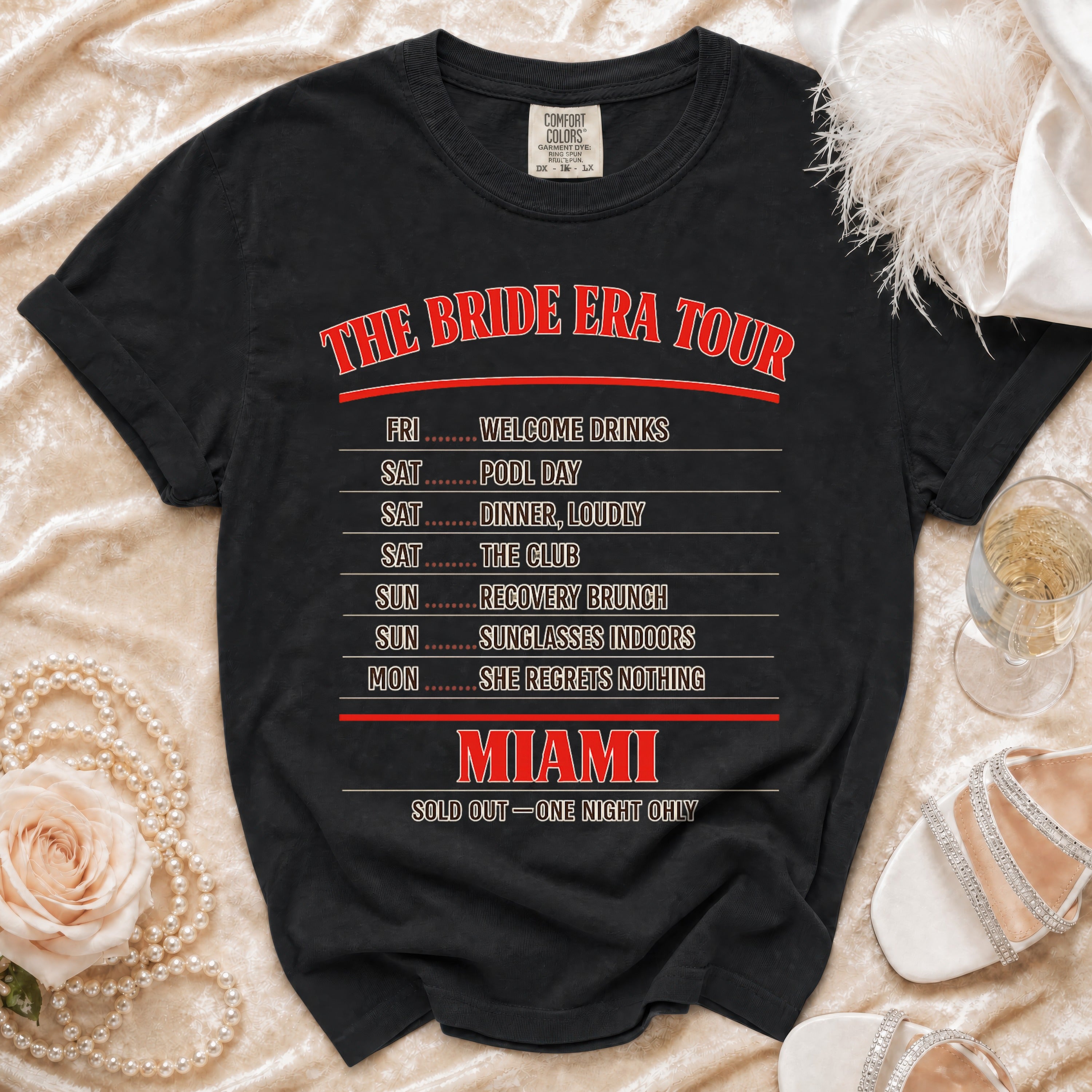 Black t-shirt with "The Bride Era Tour" and Miami itinerary including "She Regrets Nothing".